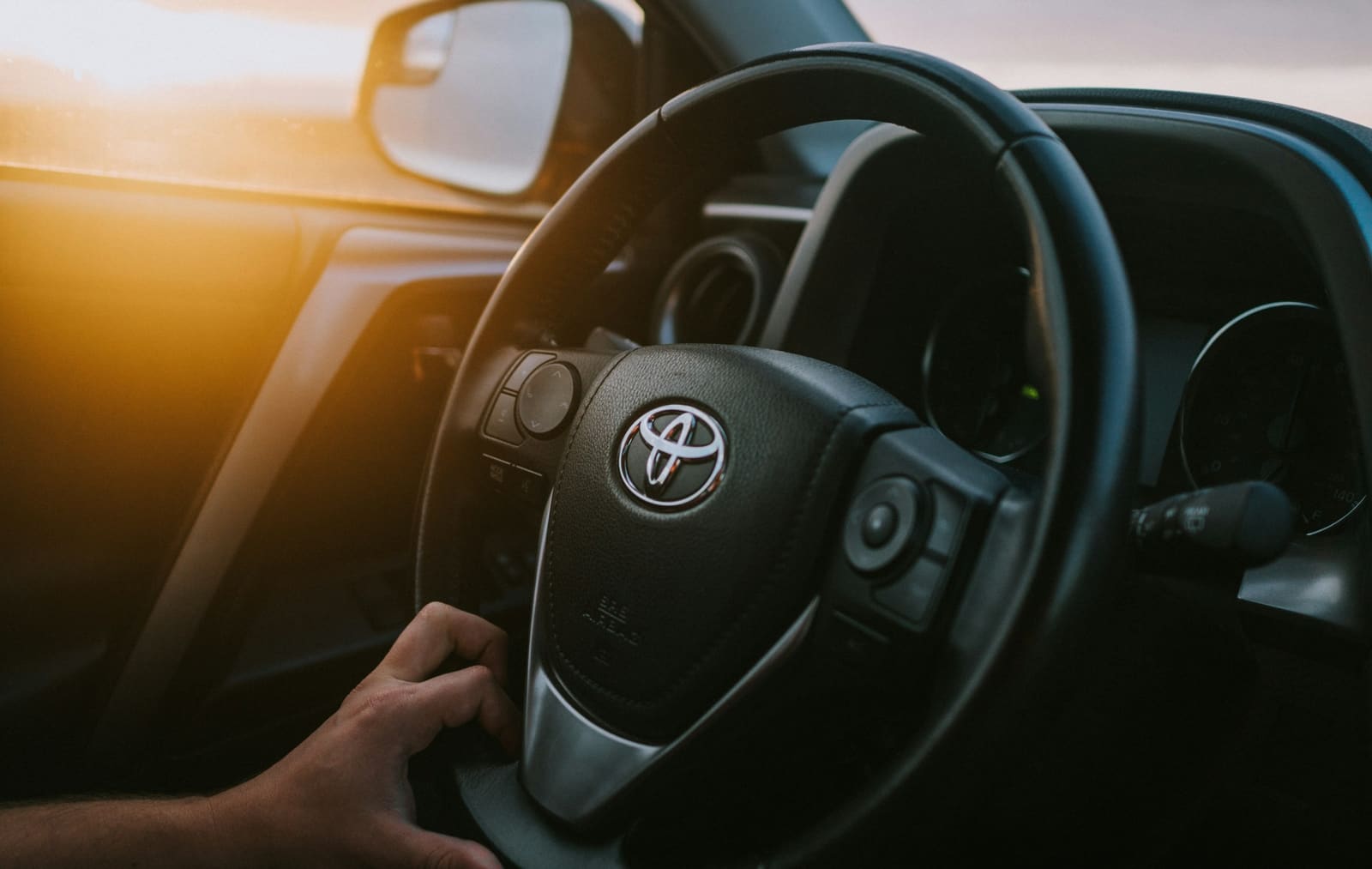 Manos al volante con el sol de la tarde entrando por la ventanilla